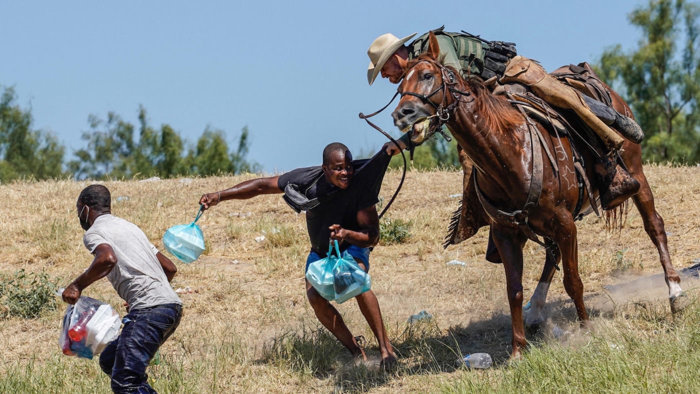 A United States Border Patrol agent on horseback tries to stop a Haitian migrant