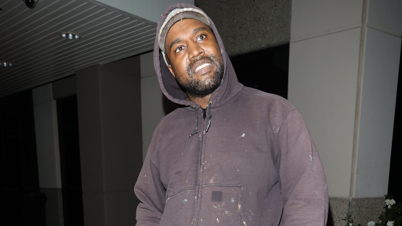 Ye is seen in a hoodie and hat outside