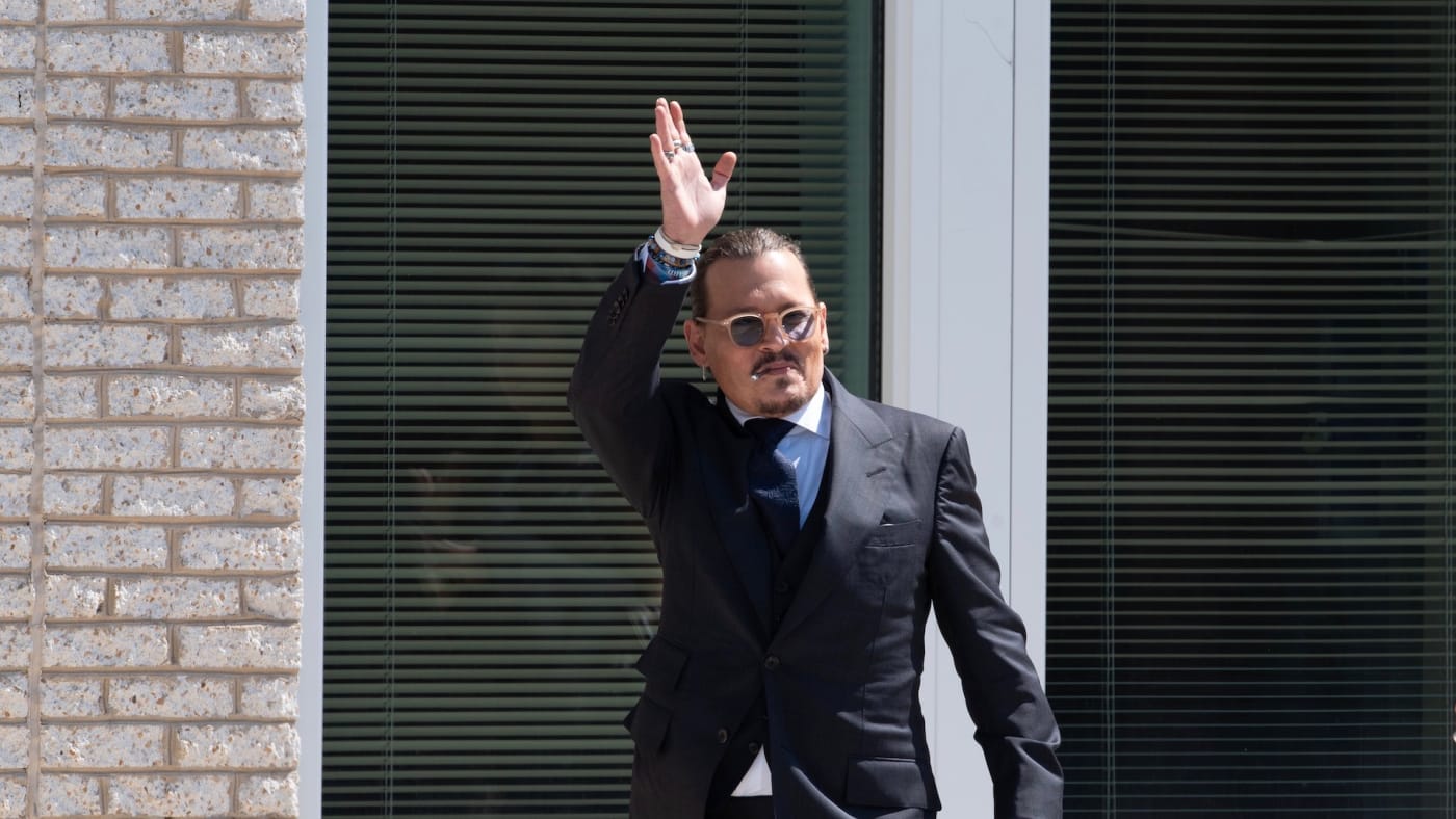 Johnny Depp gestures to fans during a break outside court