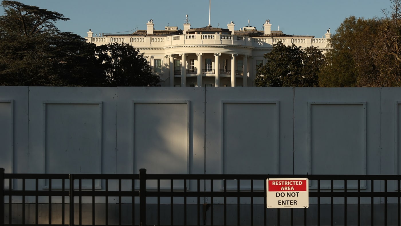 The south side of the White House is seen behind layers of fencing.