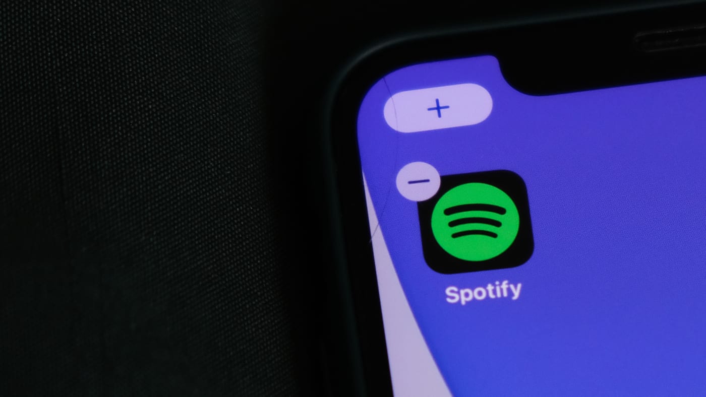 A logo for the Spotify app is pictured on a phone
