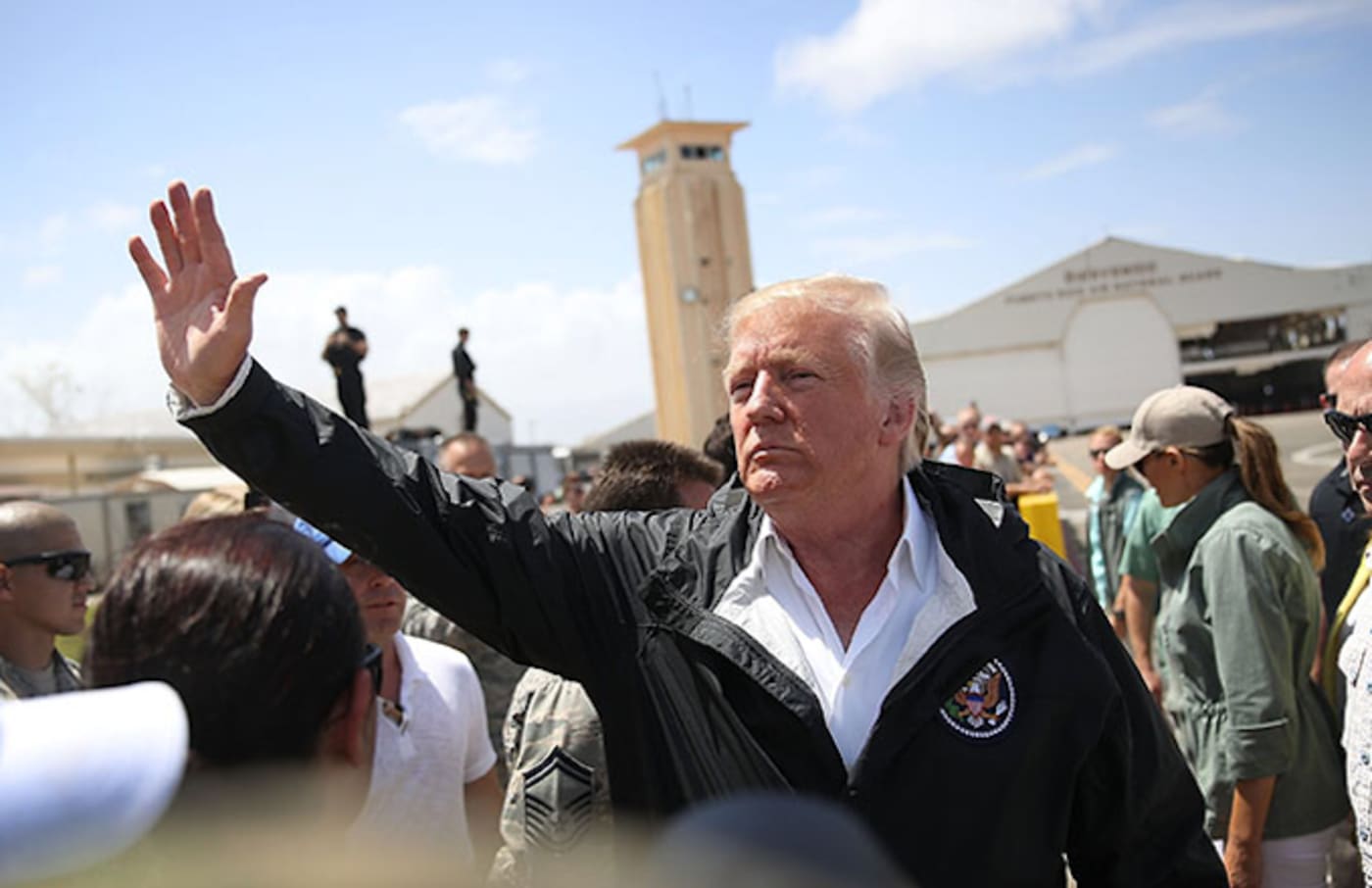 Donald Trump waves as he arrives at the Muniz Air National Guard base