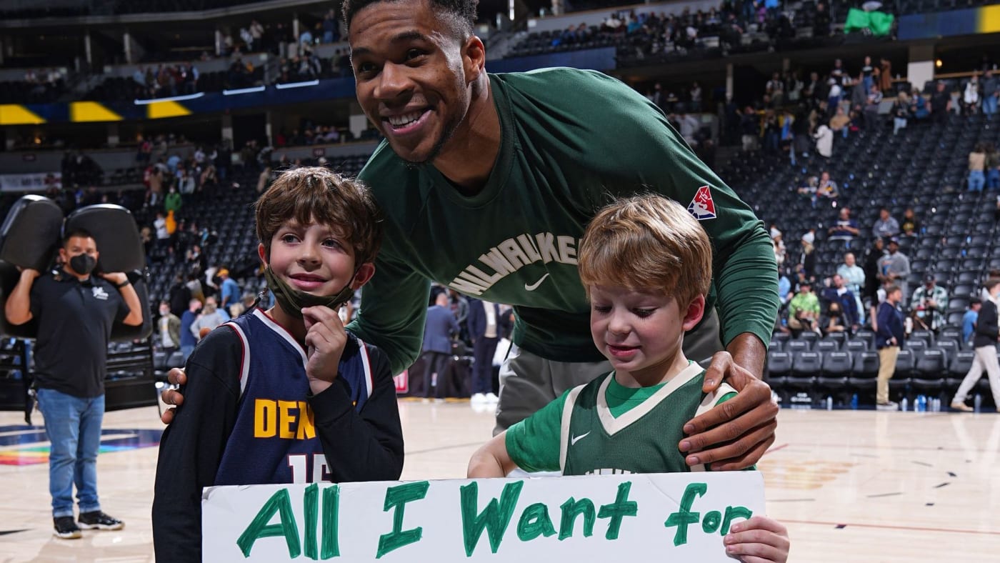 Giannis Antetokounmpo takes a picture with a young fan on his birthday