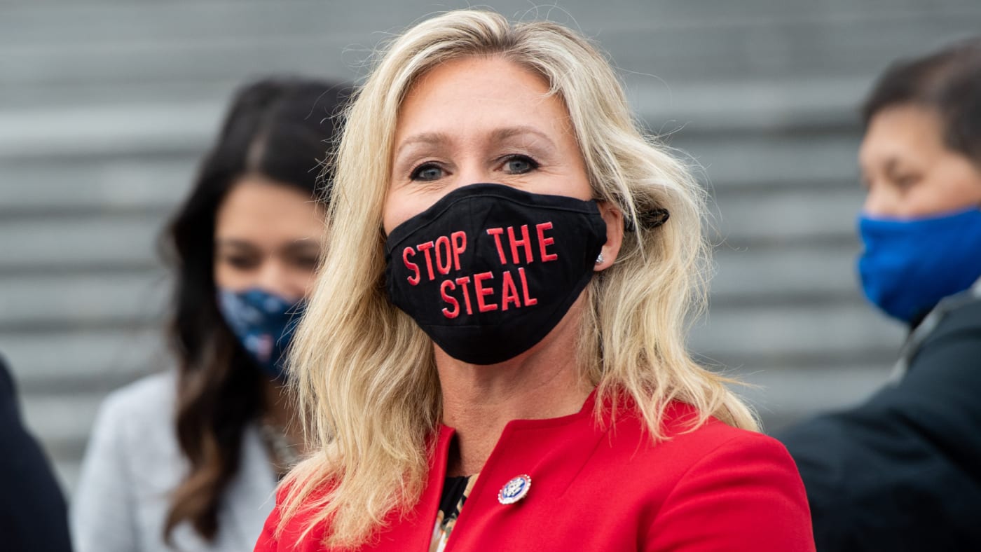 Marjorie Taylor Greene holds up a "Stop the Steal" mask.