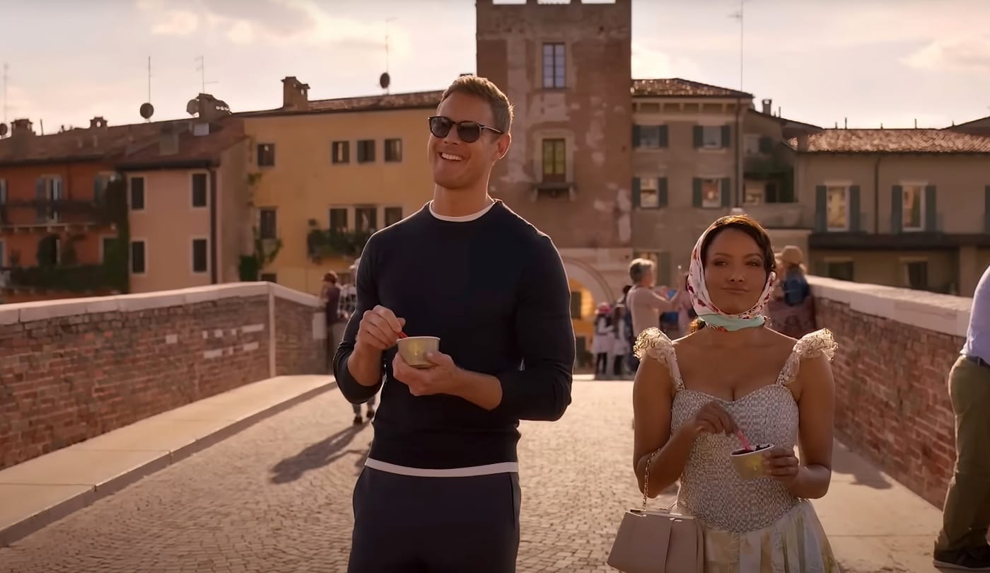 A couple walks across a bridge with ice cream.