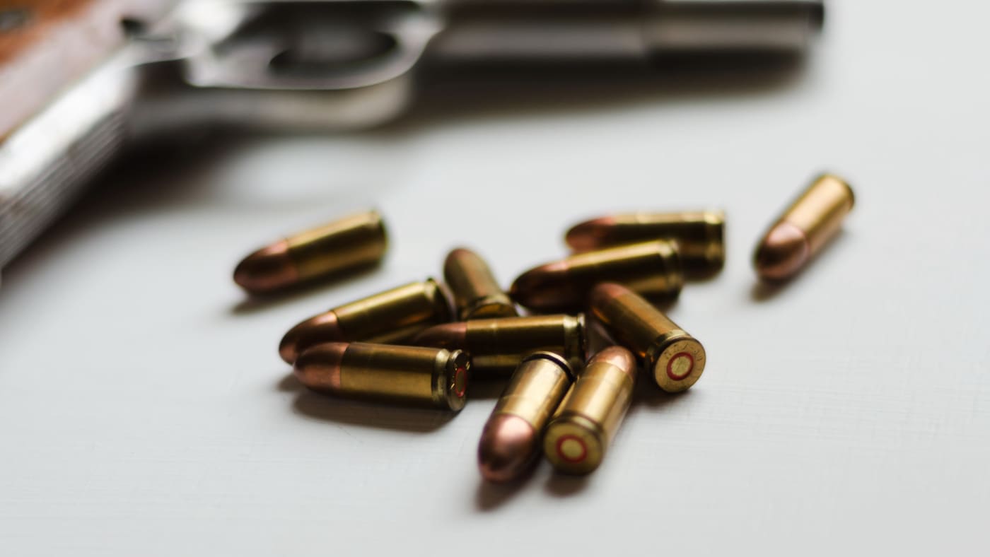 Image of a gun and bullets on table