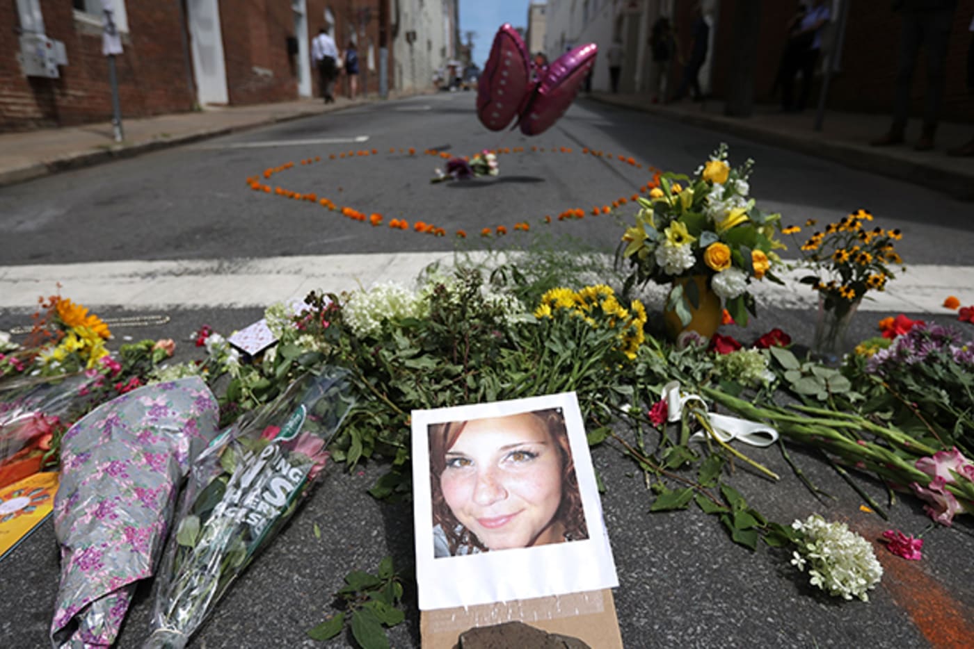 Flowers surround a photo of 32 year old Heather Heyer