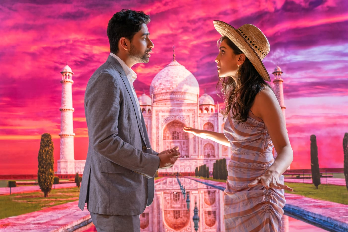 A couple stands before the Taj Mahal.