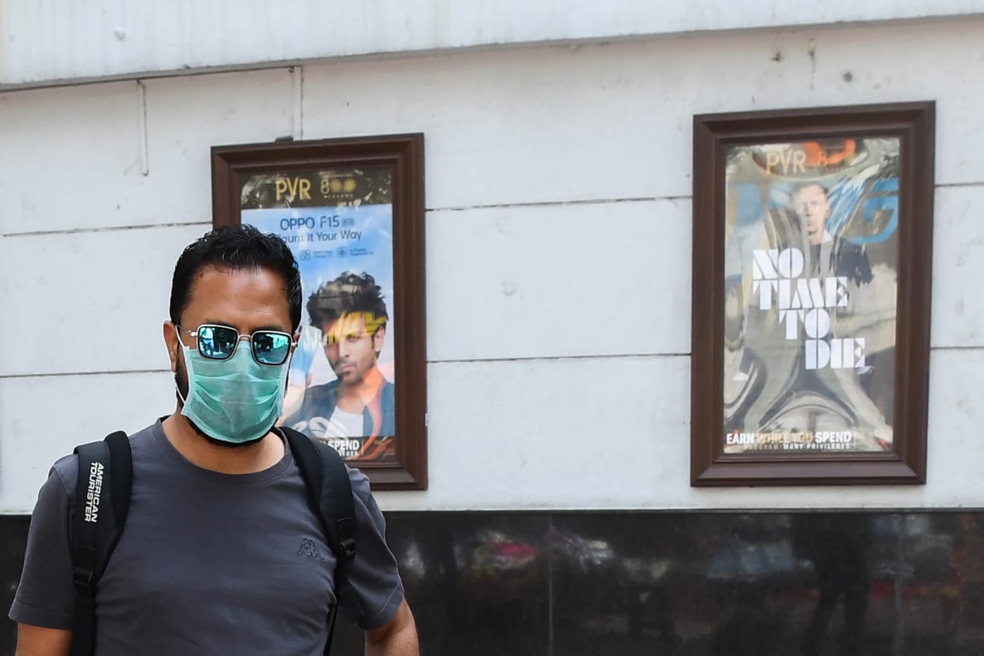 A man wearing a facemask walks pasts the closed Rivoli cinema complex in New Delhi