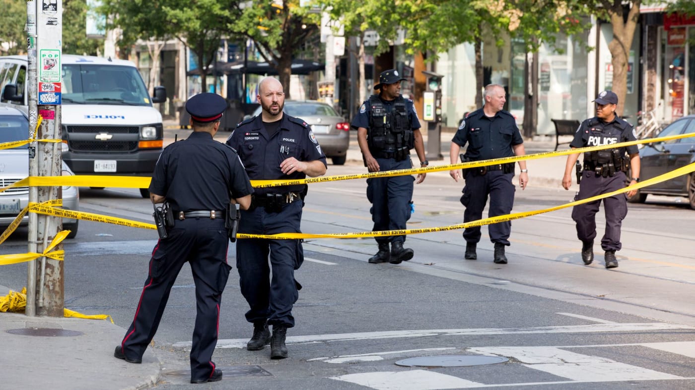 Toronto police are seen walking along Queen Street West