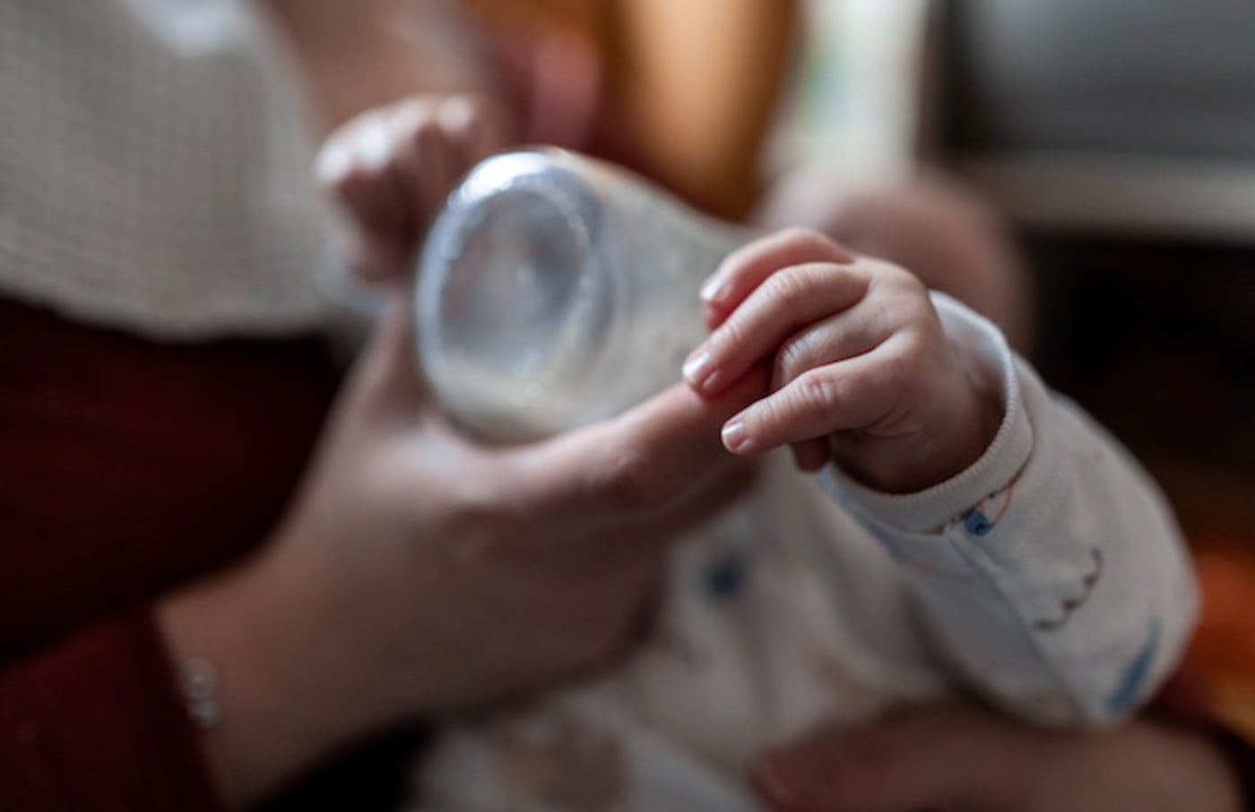 A baby drinks milk from a bottle.