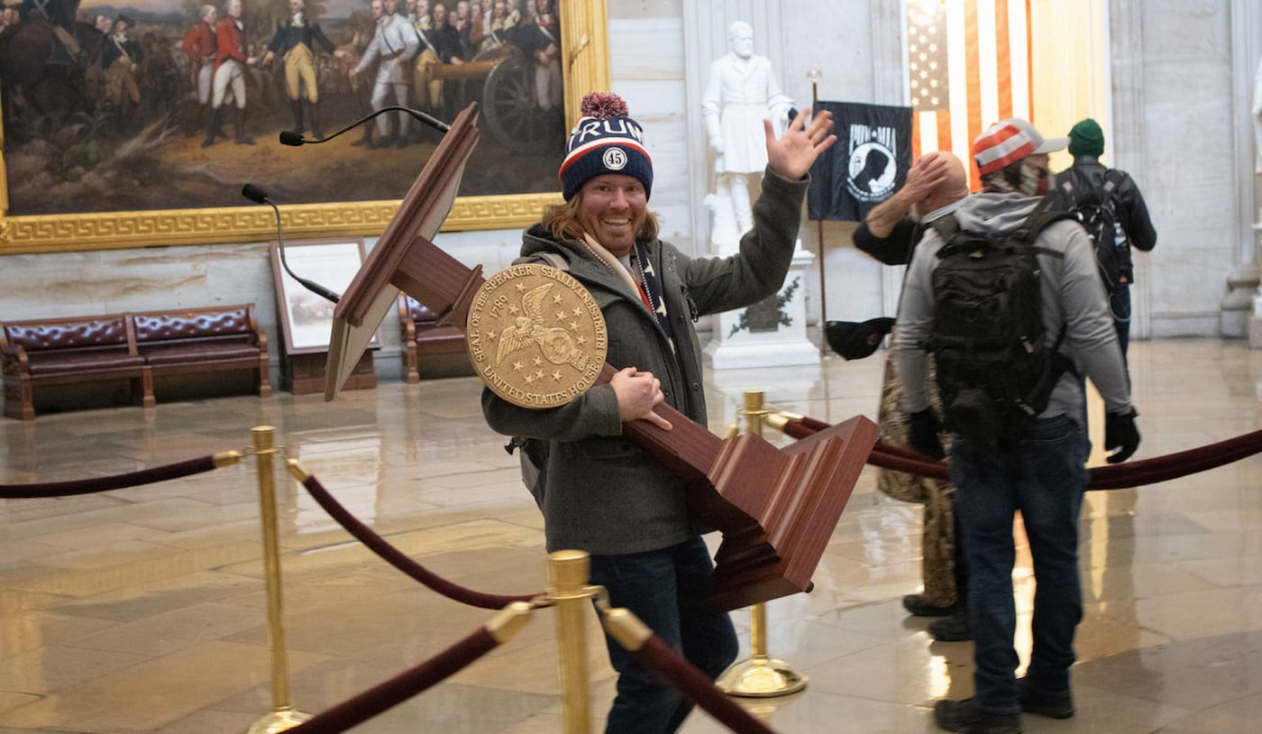 A proTrump protester carries the lectern of U.S. Speaker of the House Nancy Pelosi through the Roturnda of the U.S. Capitol