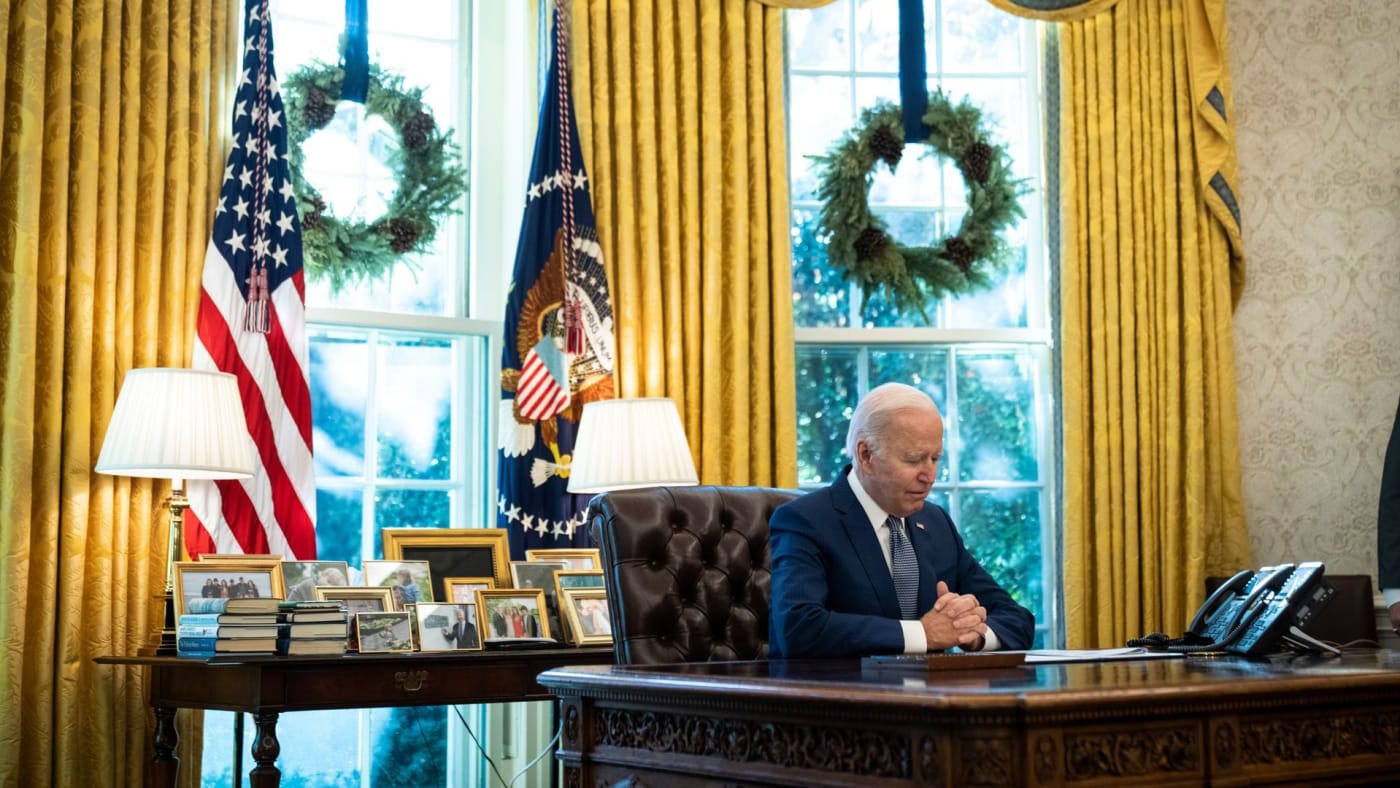Joe Biden sits in the Oval Office