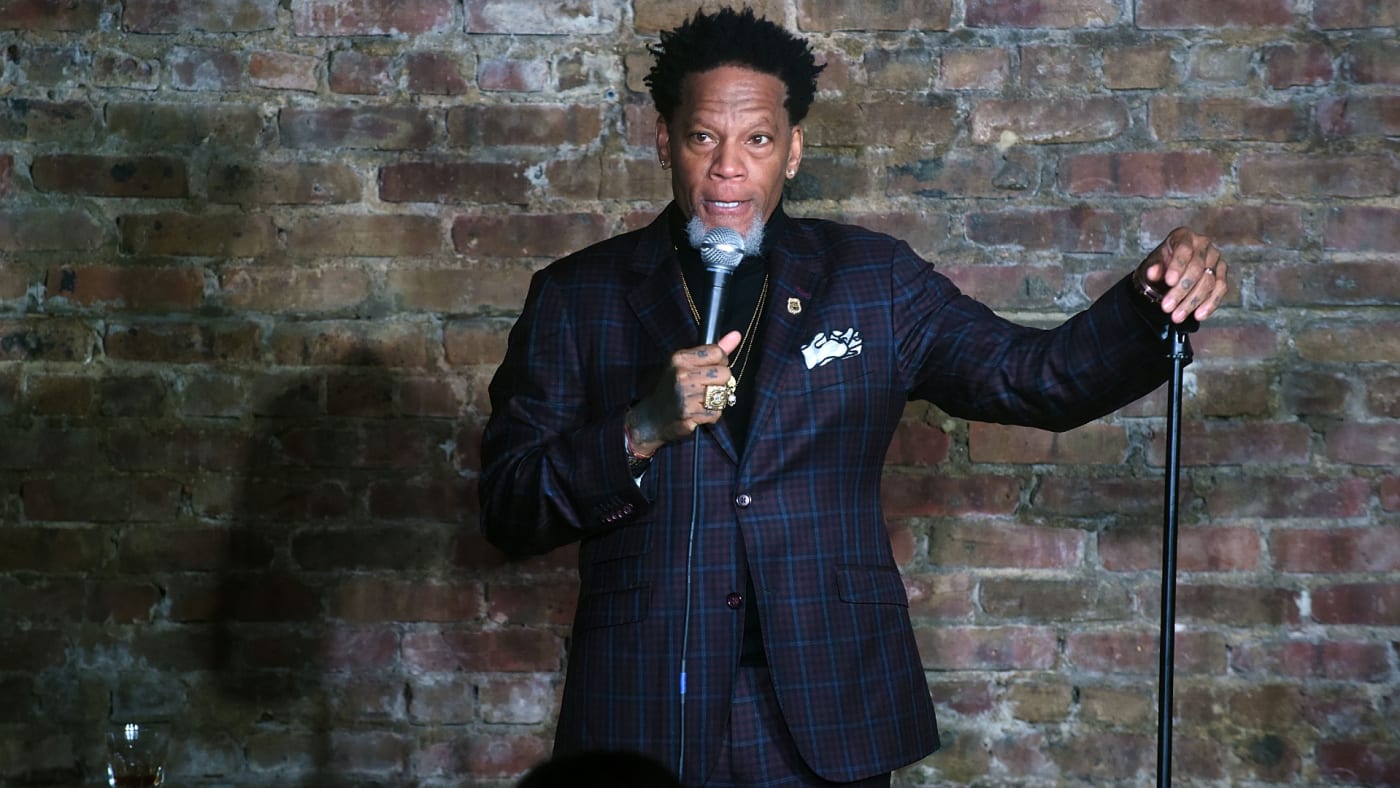 Comedian DL Hughley is pictured holding a microphone