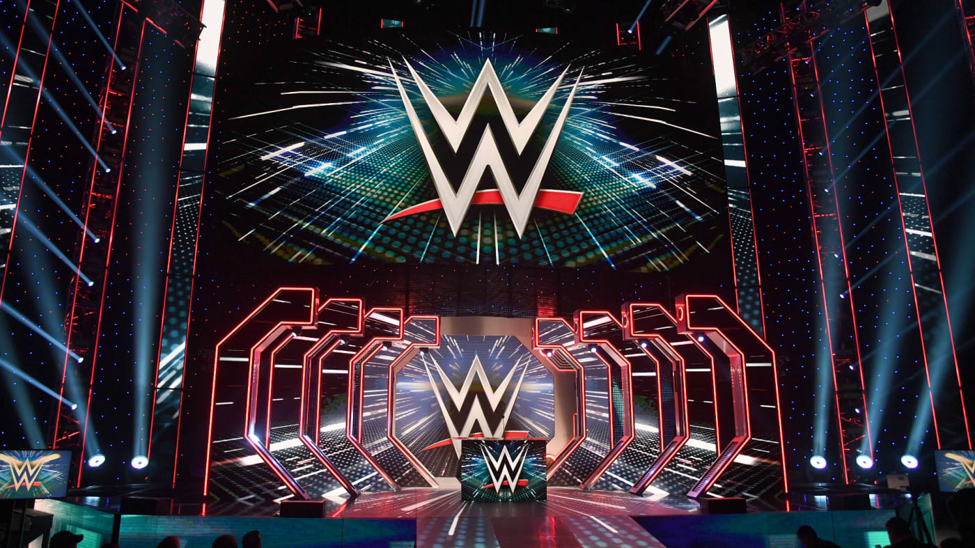 WWE logos are shown on screens before a WWE news conference at T Mobile Arena.