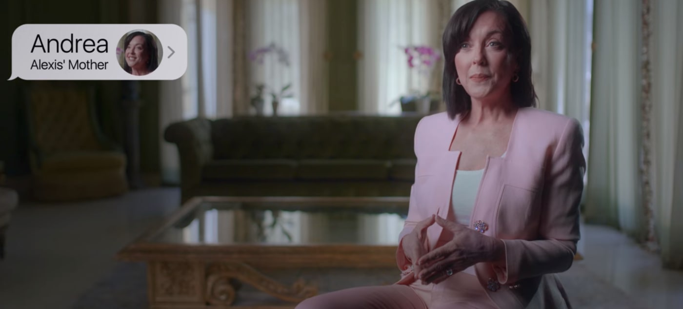 A woman in a pink suit is being interviewed.