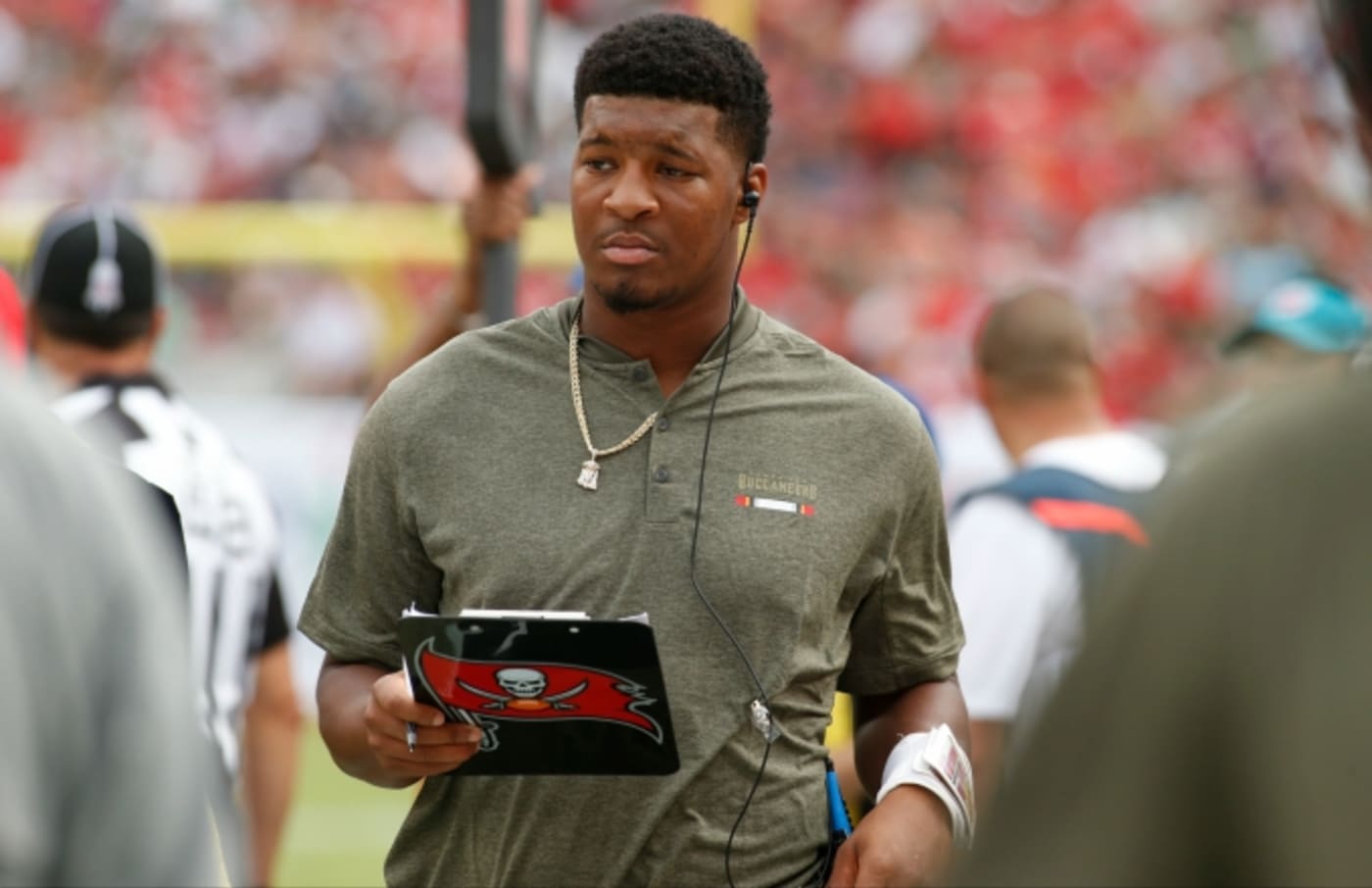 Jameis Winston stands on the sideline.