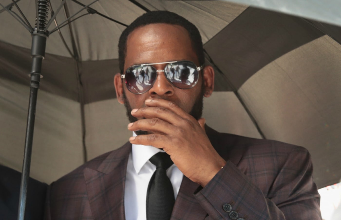 R&B singer R. Kelly covers his mouth