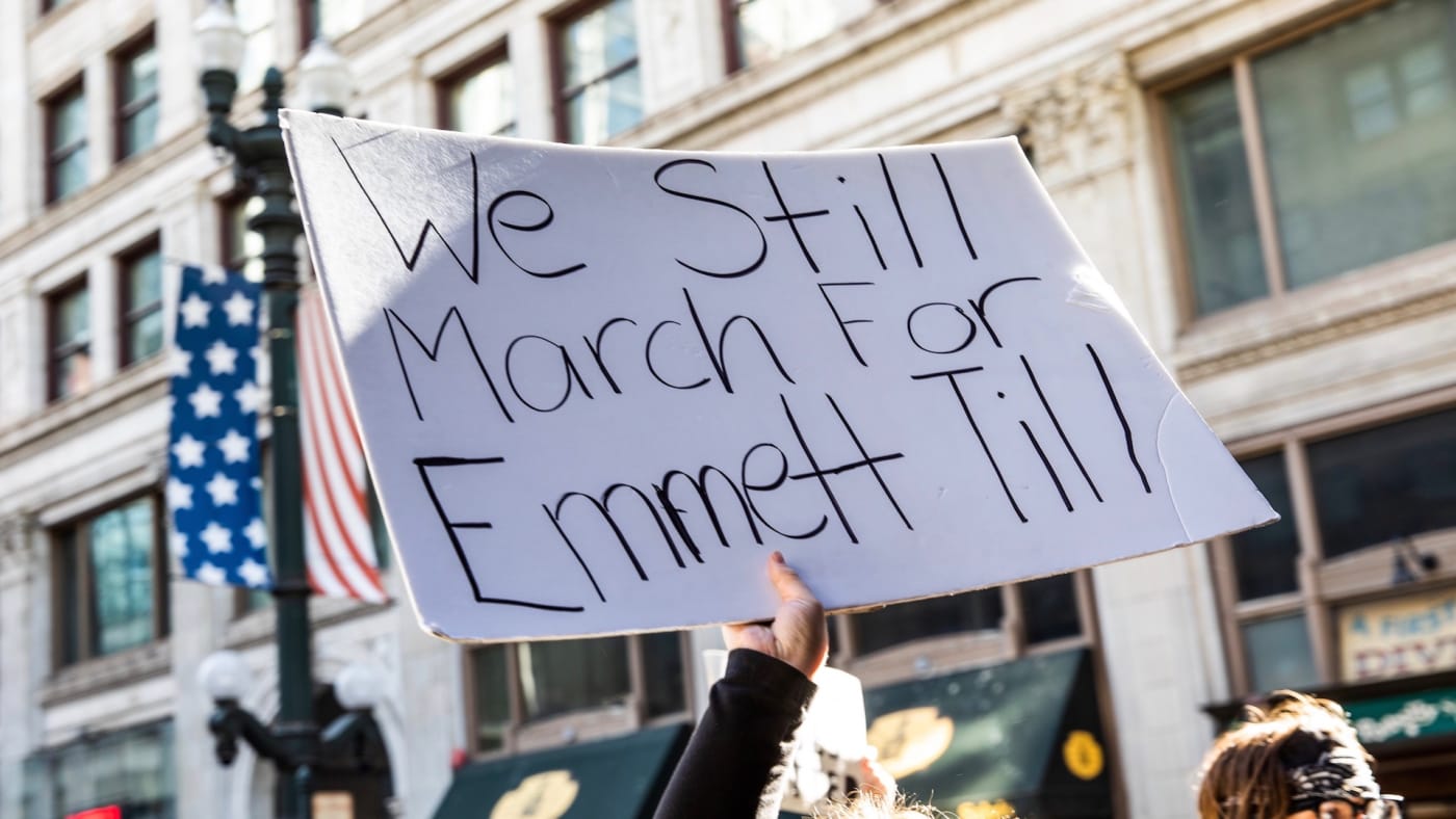 A woman holds a sign in honor of Emmett Till during a protest