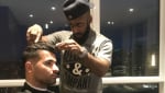 Patrice Alexander trimming a client's hair.